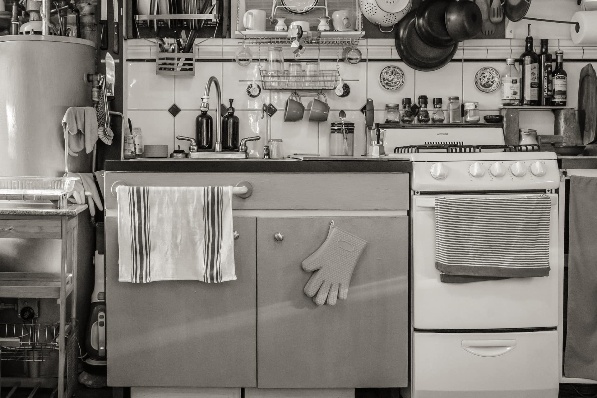 A warm home kitchen counter with pans, a board and the beginnings of a meal