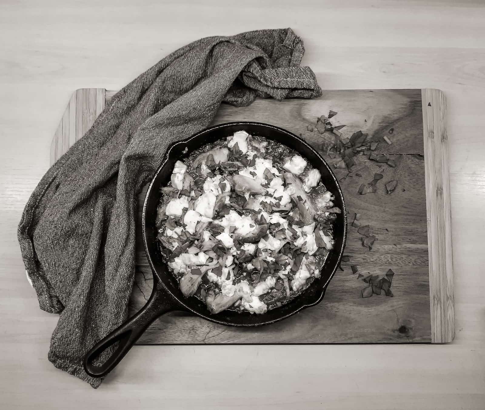 A seasoned cast iron skillet resting on a wooden board